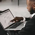 A man pointing at his laptop screen